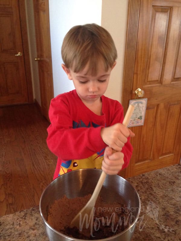 Young boy looking down as he mixes double chocolate cookie mix 