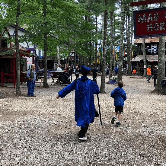 Two boys in costume at an outdoor Renaissance fair. 