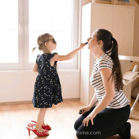 Little girl putting makeup on her mom so she can out with mom friends or her spouse