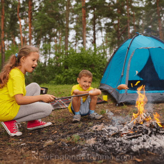 2 kids at a campfire having a campfire treat