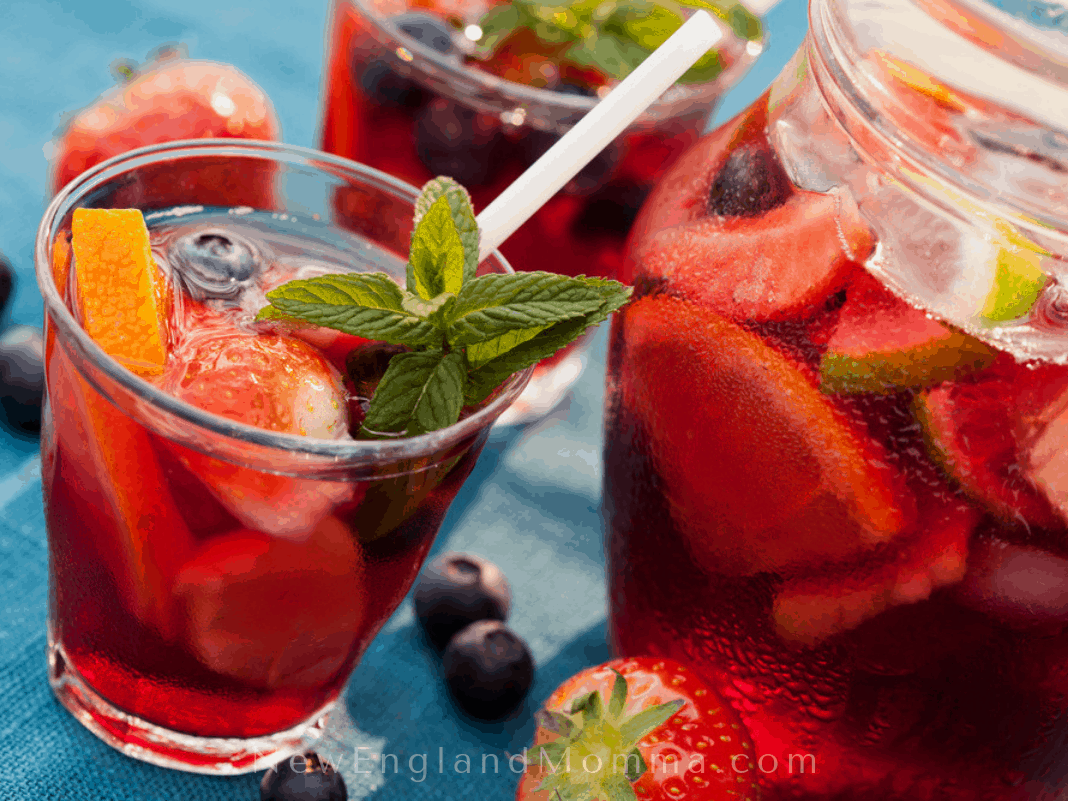 red sangria in a glass with a pitcher 