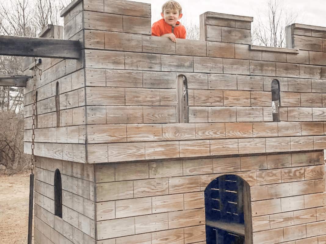 little boy playing in a castle shaped play area at Animal Adventures in Bolton, MA