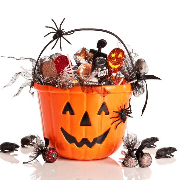 a pumpkin face basket filled with halloween candy and goodies