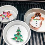 homemade Christmas bead ornaments in pans on a gas grill