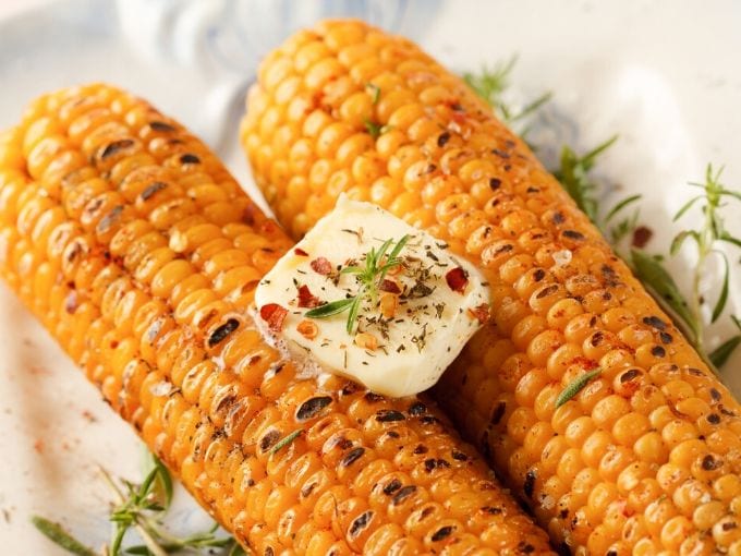 grilled corn on the cob with a square of butter and seasoning