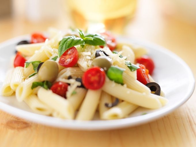 olives and cherry tomatoes mixed in pasta salad 