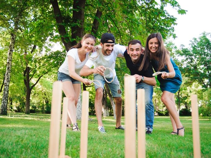 2 women and 2 men playing ring toss outdoors 