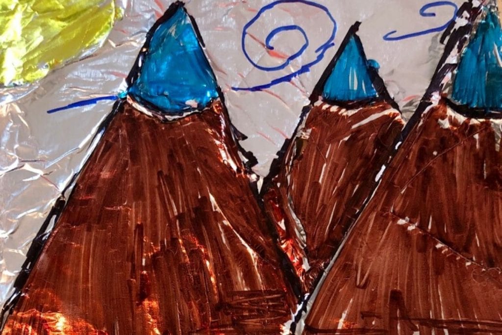 tin foil paper with picture of mountains with sun hand drawn with markers