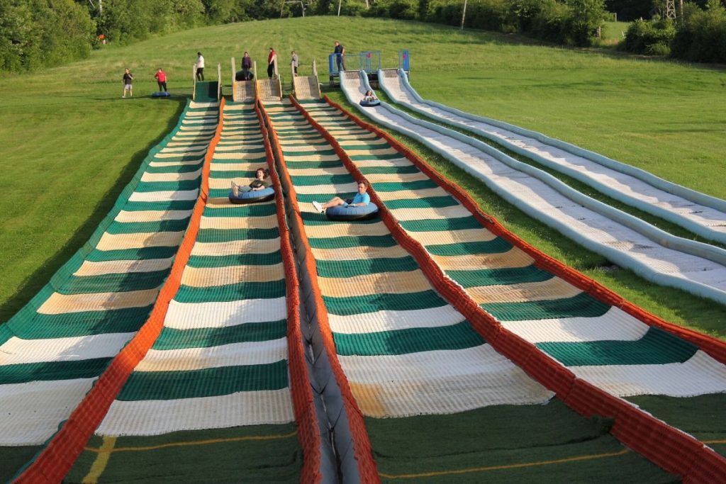 long tubing lanes with two people going down outdoor summer tubing 