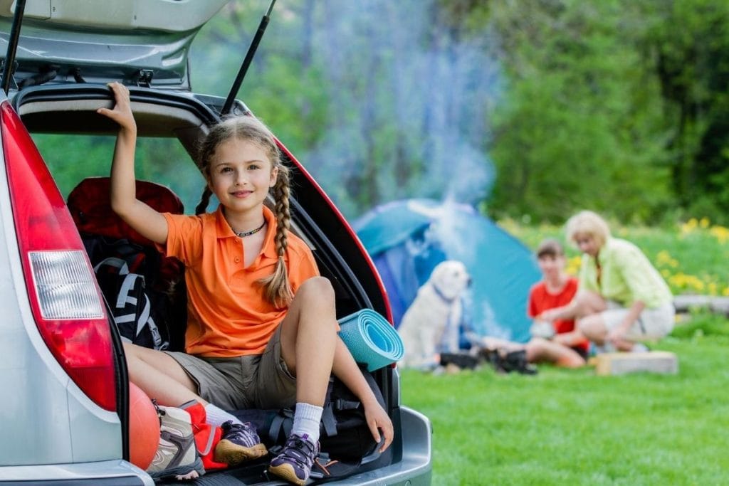 A family with their dog camping outdoors together 