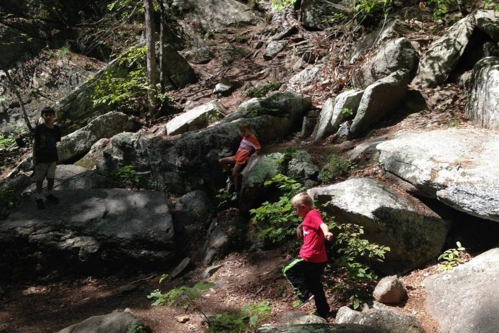 Kids having fun through a rocky chasm hike