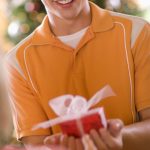 A teen boy holing a wrapped gift in his hands