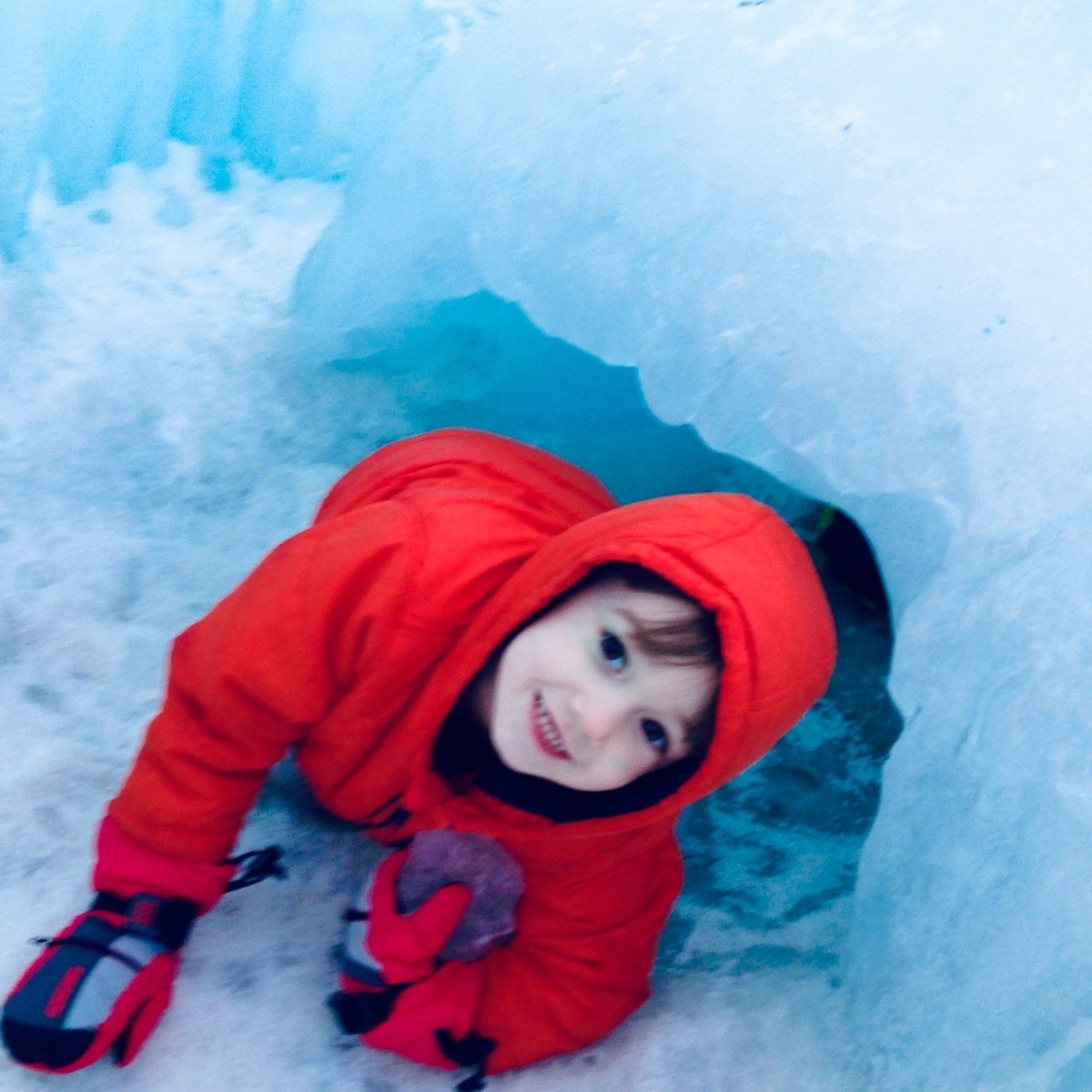 A young boy crawls through one of the many ice tunnel at the North Woodstock, NH Ice Castles.