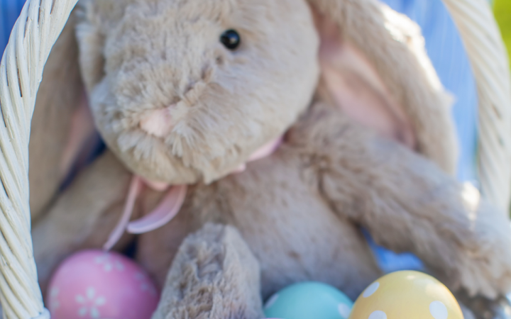 A white basket filled with Easter eggs and an plush bunny toy.
