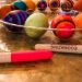 multiple Easter eggs decorated on the table with markers